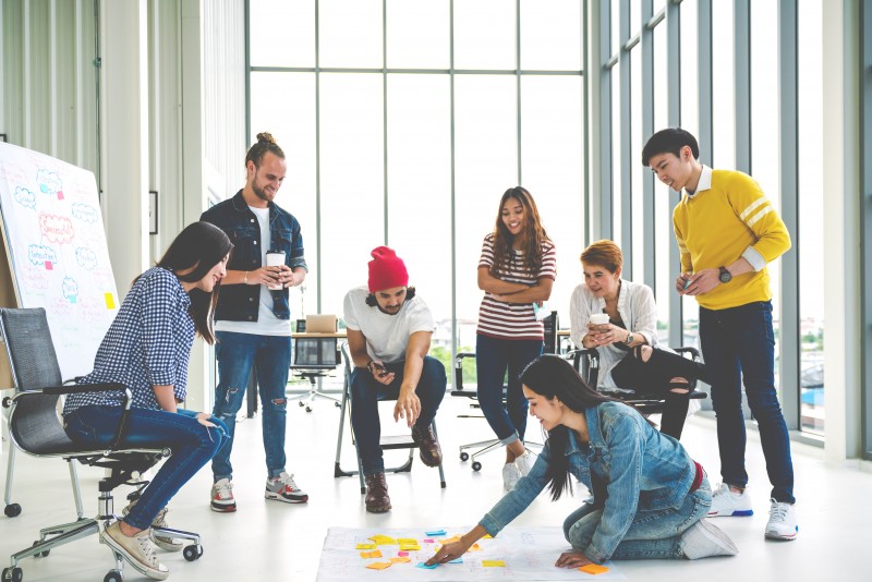 Young creative diverse group meeting and looking at project plan