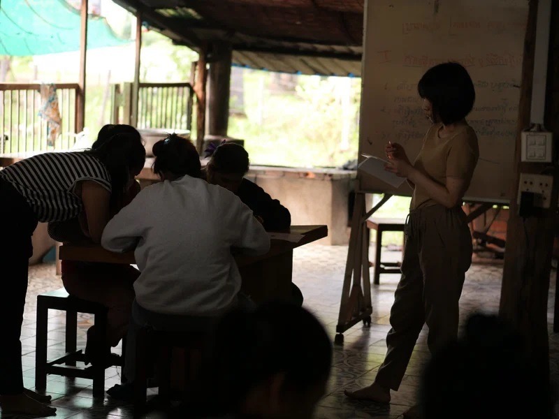 学びに熱中する生徒たちと、彼らの姿を見守る教師(右)