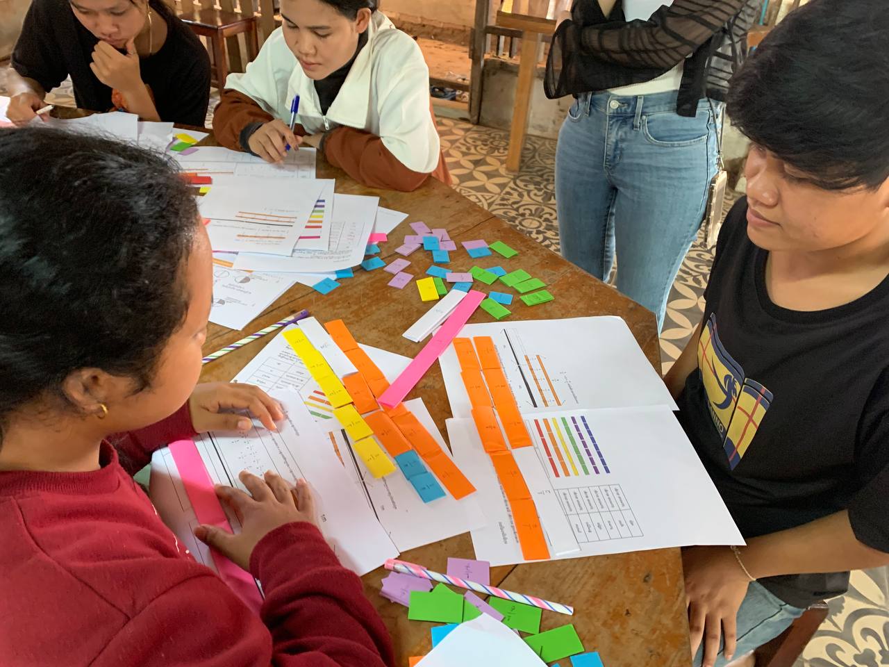 机の上には様々な資料が並ぶ。生徒たちは教え合い、学び合う