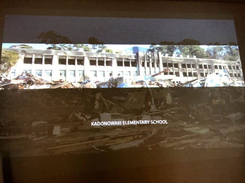 「南浜つなぐ館」で上映されたビデオの一部。津波直後の生々しい写真には、住民感情に配慮し、日本語のキャプションはつけていない。