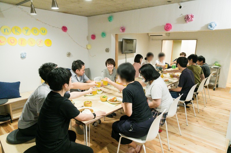 コミュニティスペースで一緒に食事をとる参加者